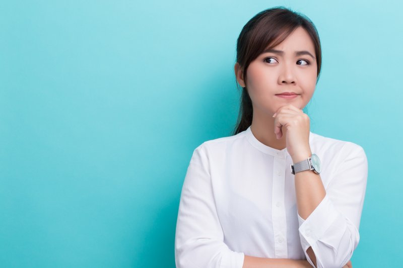 woman thinking about visiting an in-network dentist